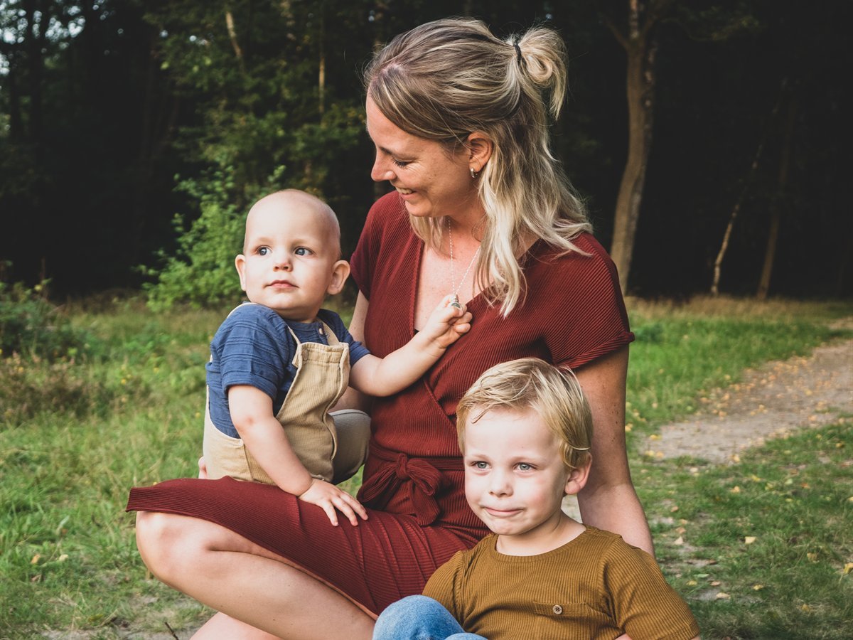 Yanieke zit op een bospad met haar twee jonge zoons bij zich.